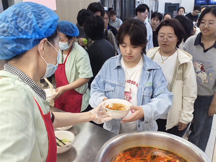 师生排队品鉴蘸水面.jpg