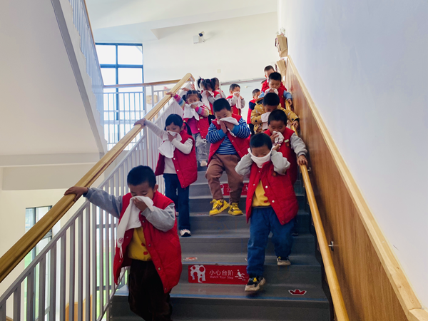 幼儿用湿毛巾捂住口鼻有序下楼梯_副本.png